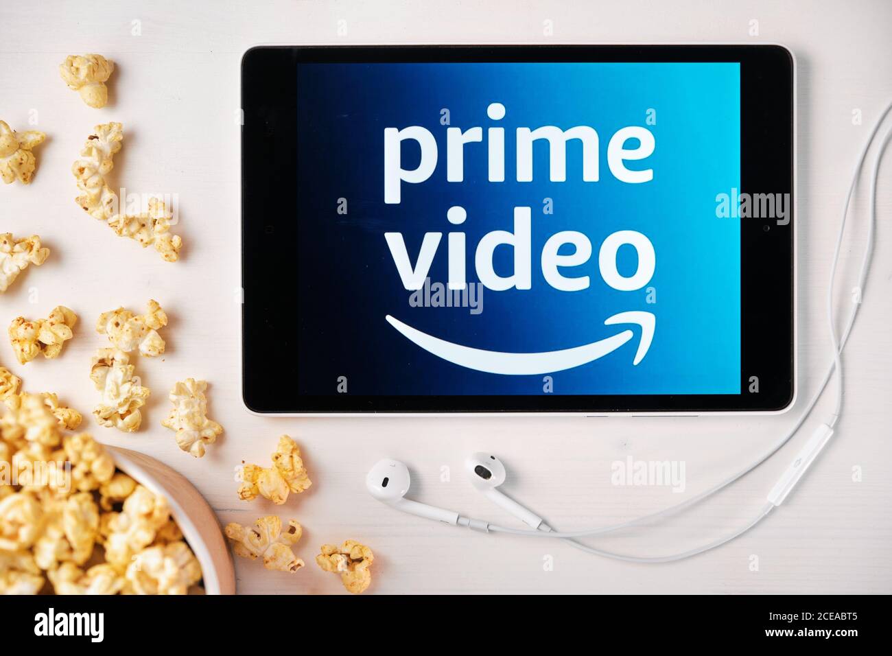 Amazon prime video logo sullo schermo del tablet che si trova sul tavolo  bianco e ha spruzzato popcorn su di esso. Auricolari Apple vicino al  tablet, agosto Foto stock - Alamy