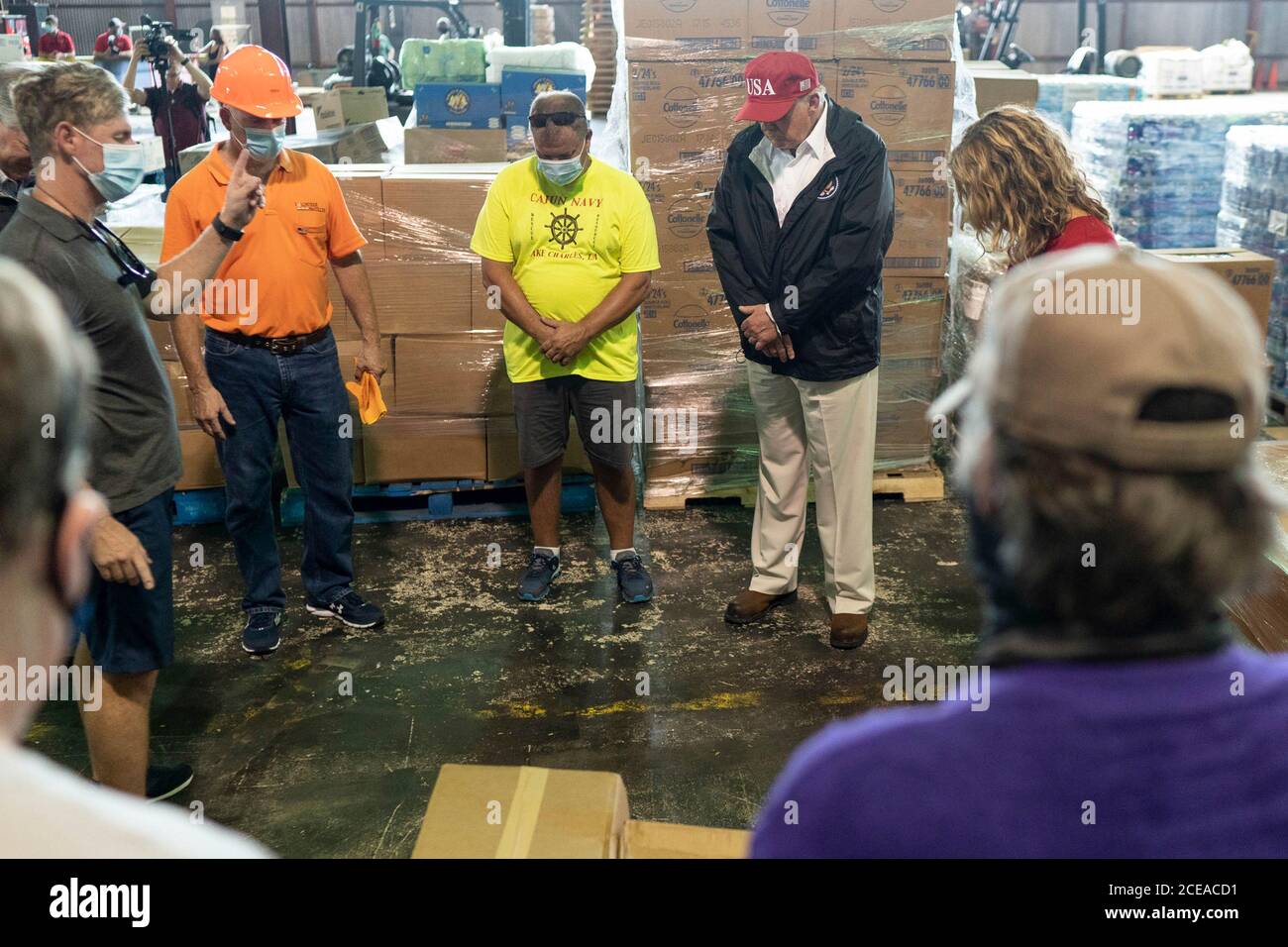 Il presidente degli Stati Uniti Donald Trump si unisce a una preghiera durante una visita al magazzino del Cajun Navy Relief Center per l'assistenza all'uragano Laura il 29 agosto 2020 a Lake Charles, Louisiana. Foto Stock
