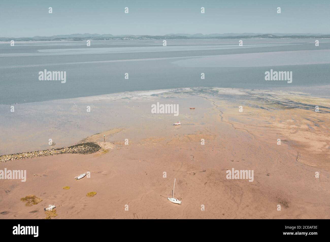Spiaggia di sabbia a bassa marea con catena montuosa sullo sfondo. Morecambe in Lancashire, Regno Unito Foto Stock