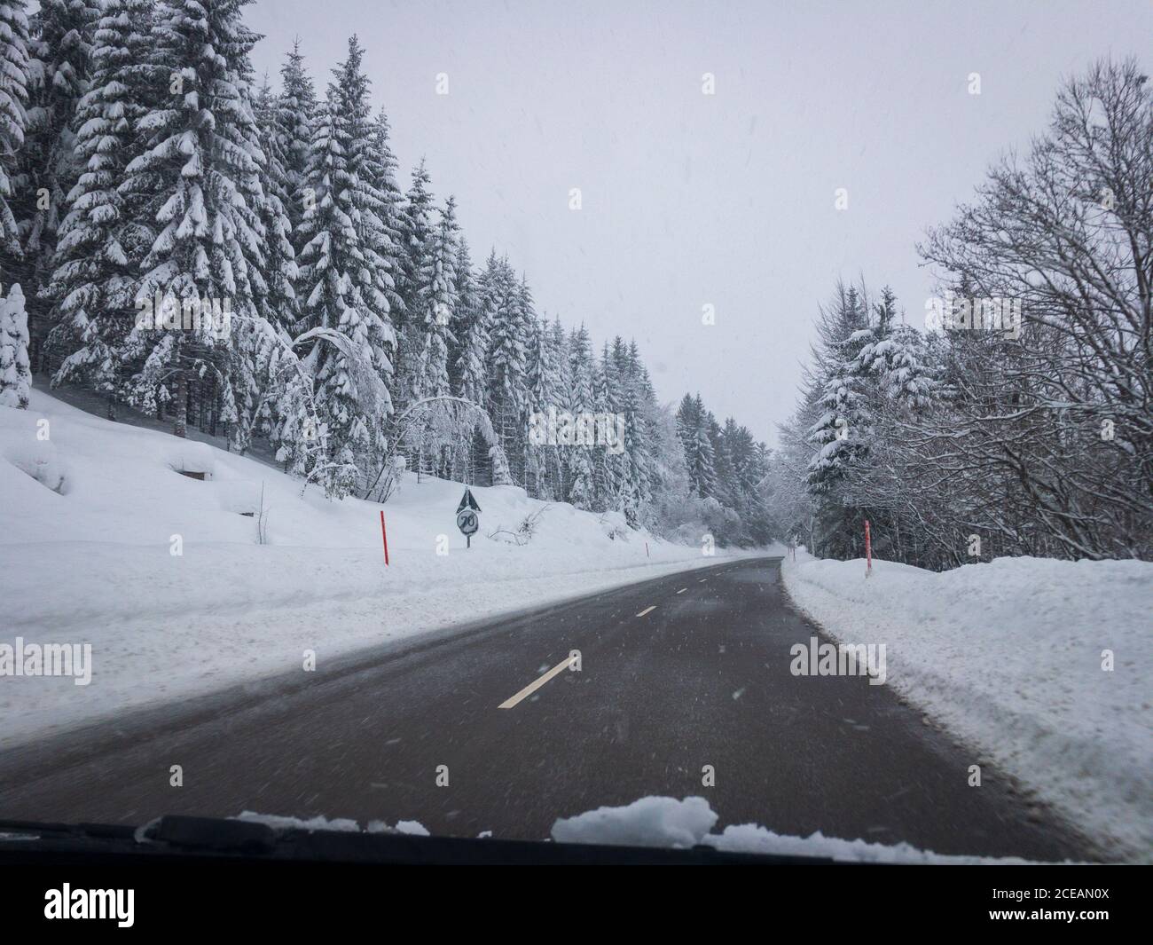 Buone condizioni stradali durante una giornata invernale con nevicate viste dall'interno di un'auto Foto Stock