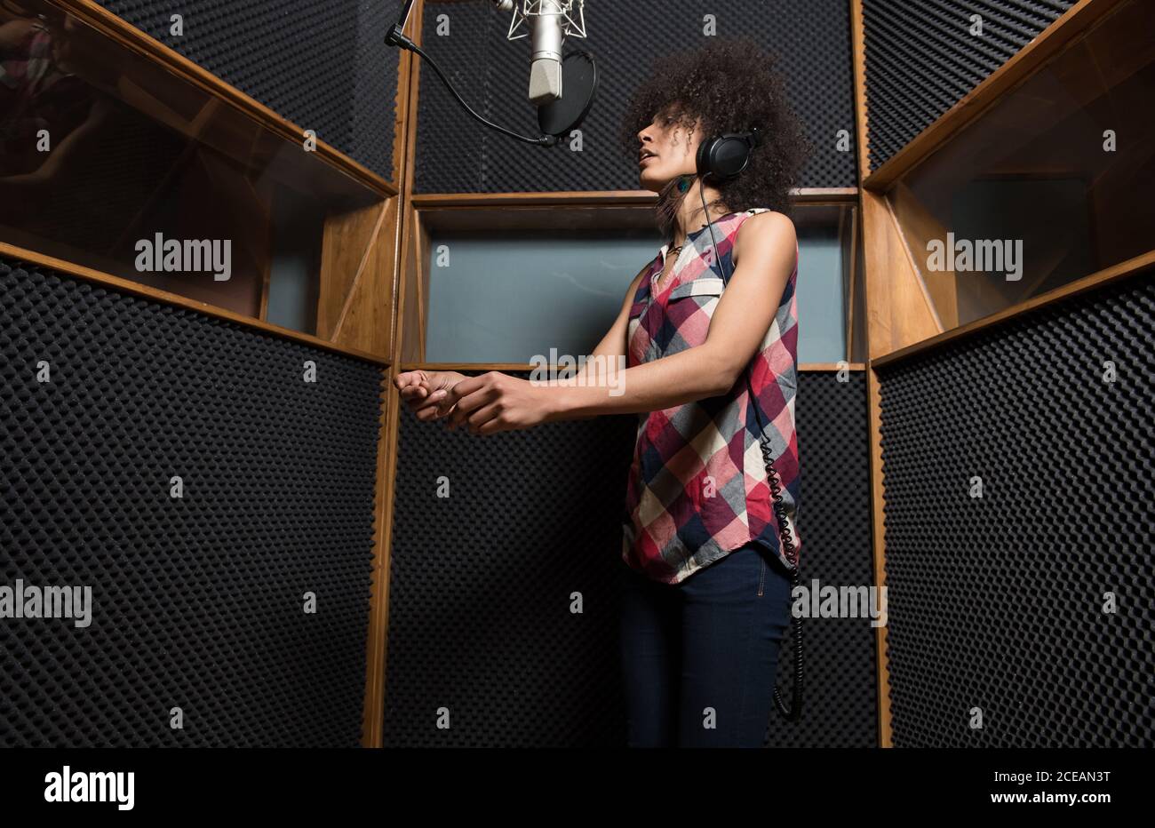Giovane donna che canta in studio Foto Stock