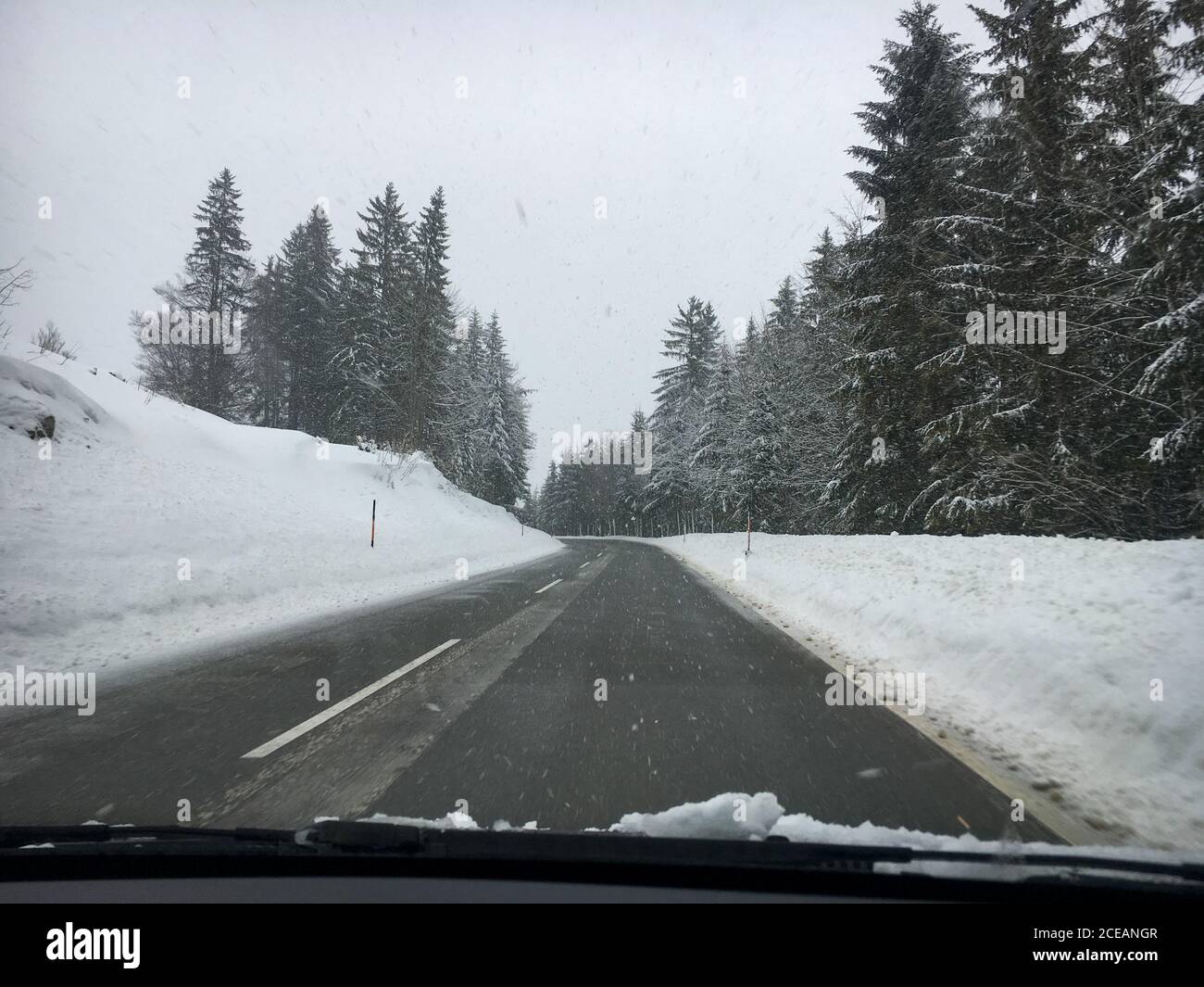 Buone condizioni stradali durante una giornata invernale con nevicate viste dall'interno di un'auto Foto Stock