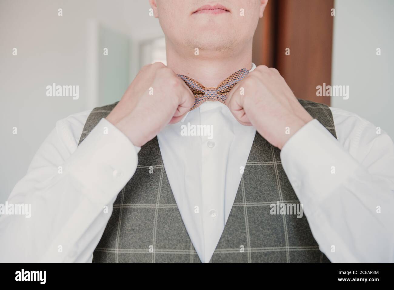 Uno sposo che regola la sua cravatta di prua Foto Stock