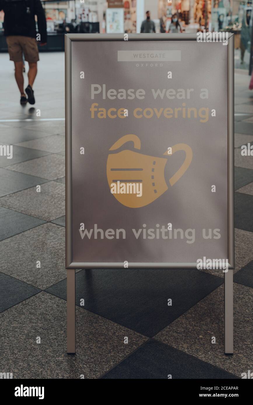 Oxford, Regno Unito - 04 agosto 2020: Si prega di indossare un cartello con la copertura del viso all'interno del Westgate Center, un importante centro commerciale nel centro di Oxford, Inghilterra. Foto Stock