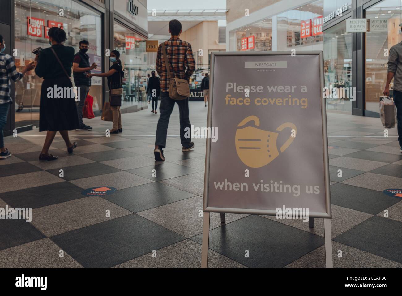 Oxford, Regno Unito - 04 agosto 2020: Si prega di indossare un cartello con la copertura del viso all'interno del Westgate Center, un importante centro commerciale nel centro di Oxford, Inghilterra. Foto Stock