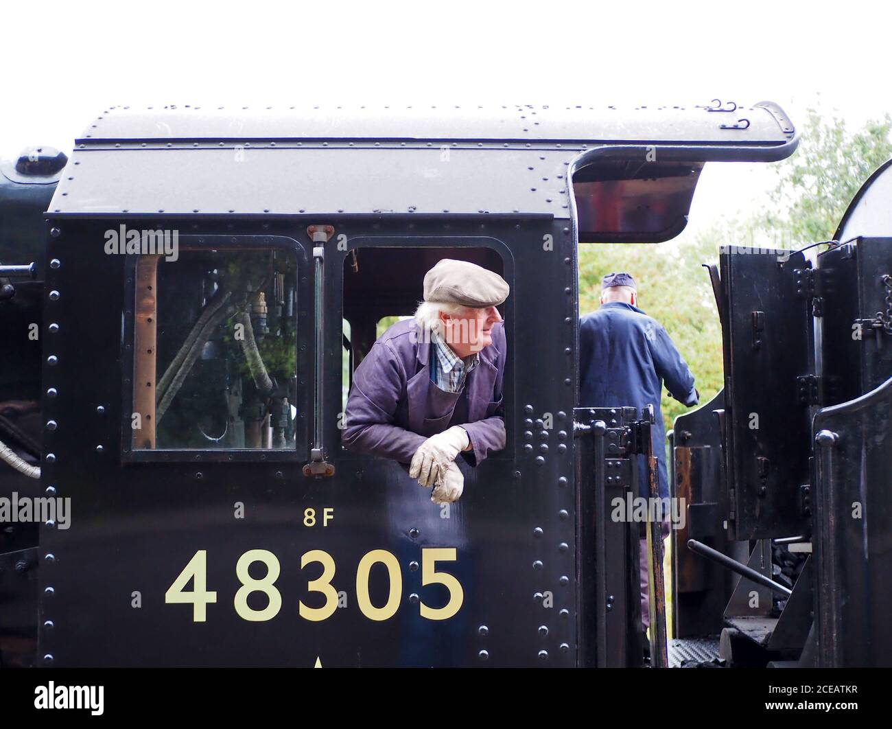 Il conducente si è inclinato fuori dalla cabina di 48395, una locomotiva a vapore Stanier LMS 8F Classe 2-8-0 Foto Stock