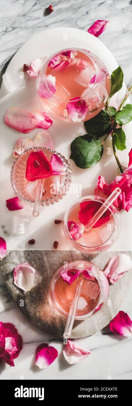 Limonata di rose con cubetti di ghiaccio e petali di rosa, ampia composizione Foto Stock