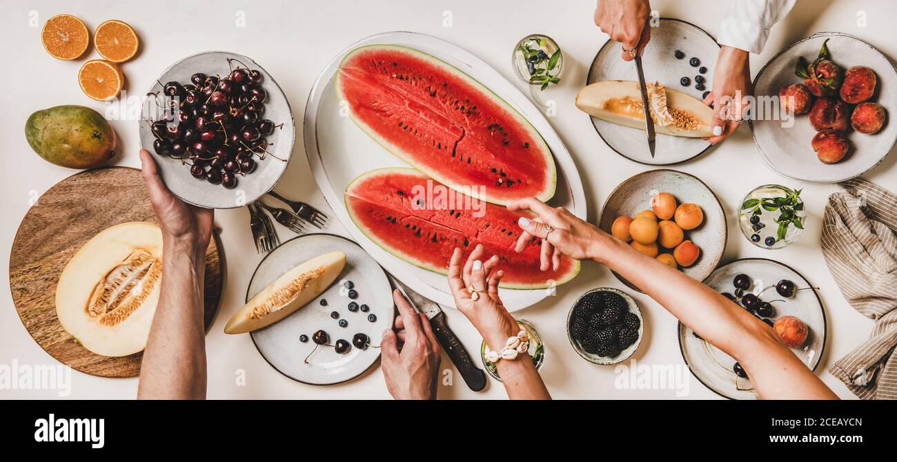 Piatto di mani di popoli con frutta, bacche e limonata Foto Stock