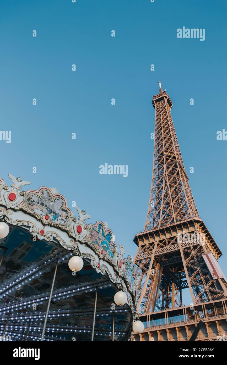 Da sotto la colorata giostra e la Torre Eiffel nel cielo limpido di Parigi, Francia. Foto Stock