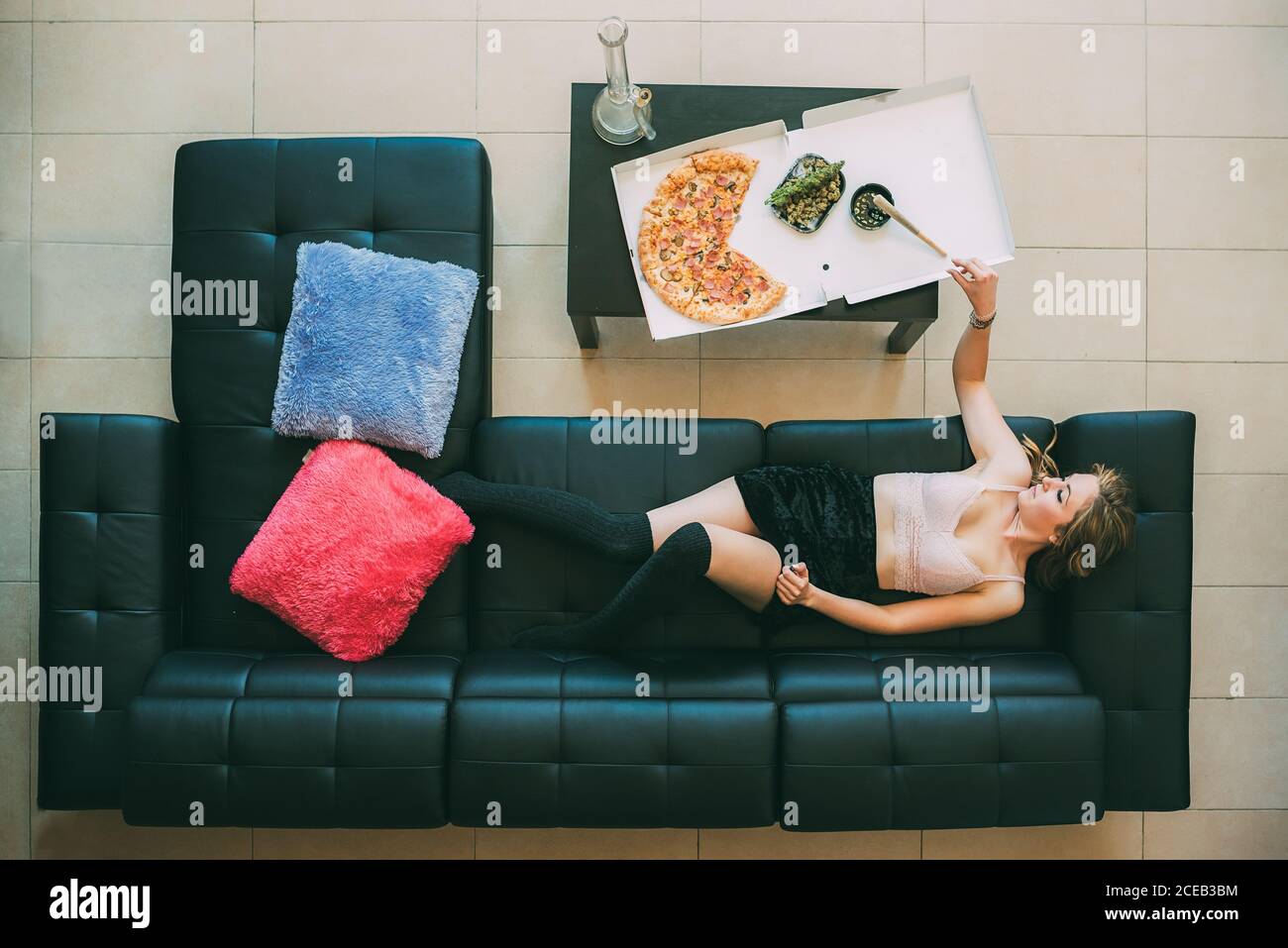 Donna sdraiata sul divano con giunto marijuana Foto Stock