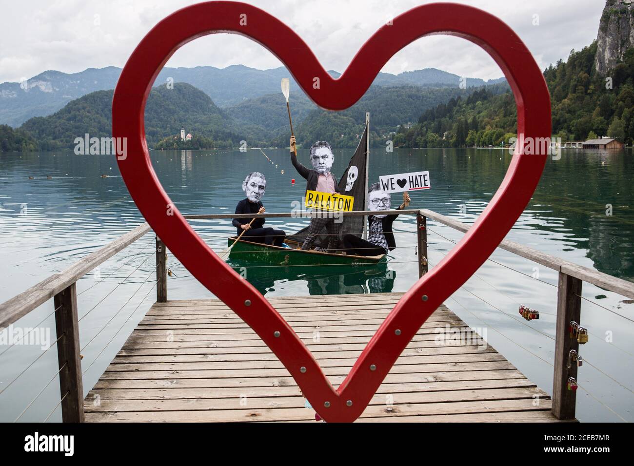 Un gruppo di manifestanti che indossano maschere di carta mostranti i volti del primo ministro sloveno Janez Jansa, del primo ministro ungherese, Viktor Orban e del presidente serbo, Aleksandar Vucic ROW una piccola barca a vela sul lago Bled che protestava contro la loro politica e l'ascesa del fascismo in Europa. La protesta si è svolta accanto al 15° forum strategico di Bled, dove il primo ministro sloveno Janez Jansa ha ha ospitato il primo ministro ungherese Viktor Orban e il presidente serbo Aleksandar Vucic, Oltre ai primi ministri della Repubblica ceca, della Bulgaria, della Polonia, della Croazia e di altri paesi. Foto Stock