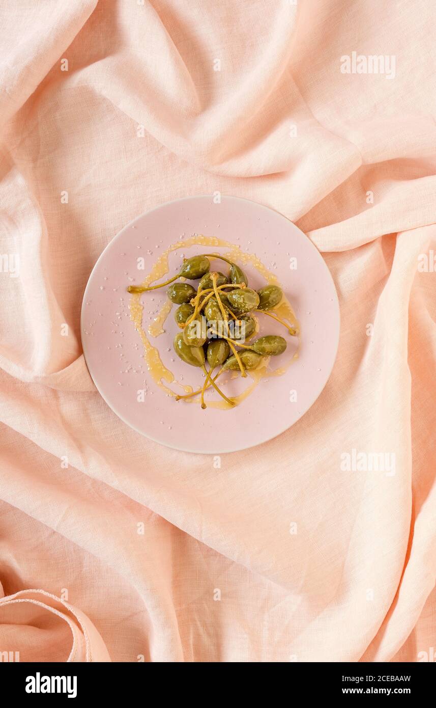 Capperi in aceto con olio d'oliva e sale. Flay superiore; vista dall'alto Foto Stock