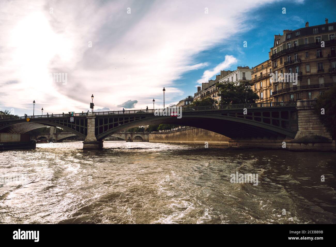 Grande ponte di fiume con lanterne sotto il cielo blu nuvoloso in Parigi Foto Stock