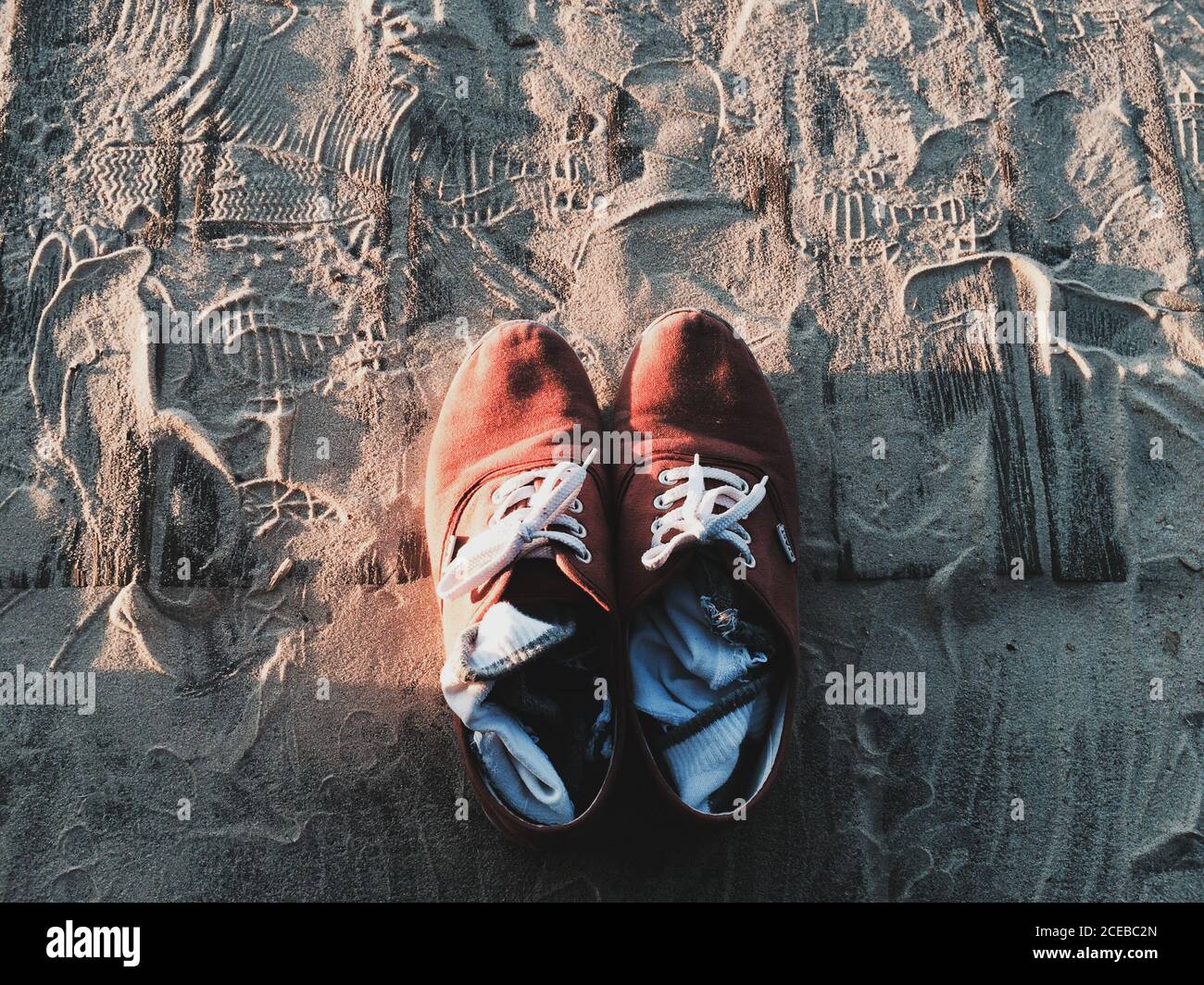 Tolto scarpe e calze alla luce del sole sulla spiaggia durante una serata meravigliosa. Foto Stock