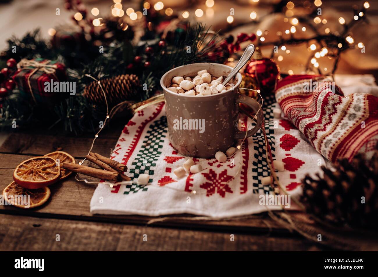 Varie decorazioni natalizie giacciono vicino alla tazza di delizioso cioccolato caldo e spezie aromatiche Foto Stock