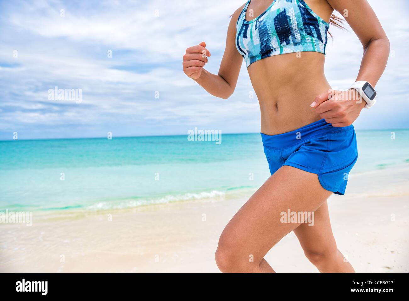 Fitness sport Smart Watch tecnologia indossabile smartwatch runner girl allenamento cardio all'esterno sulla spiaggia. Allenamento donna running. Foto Stock