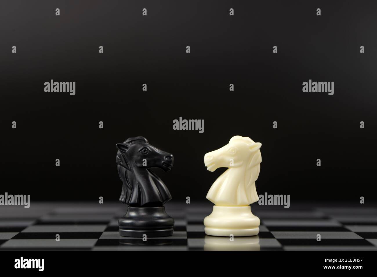 Pedine bianche e nere rivolte l'una verso l'altra Foto Stock