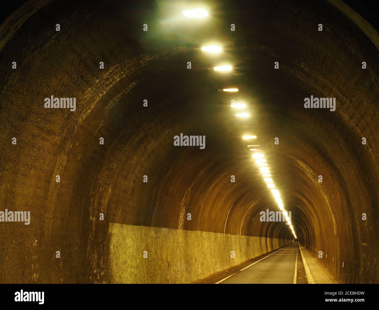 Vista prospettica del vuoto di calcestruzzo rotonda galleria illuminata con lampade a soffitto Foto Stock