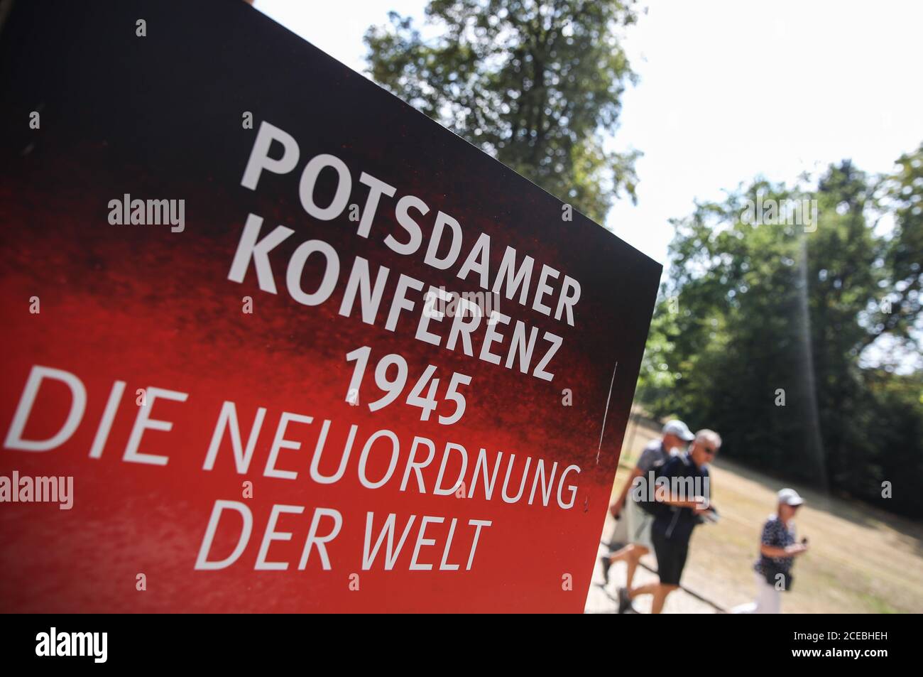 (200901) -- POTSDAM, 1 settembre 2020 (Xinhua) -- i turisti camminano oltre un manifesto della mostra speciale 'Potsdam Conference 1945 -- Shaping the World' al Palazzo Cecilienhof a Potsdam, Germania, 17 agosto 2020. Il Palazzo Cecilienhof, situato in un grande parco, è noto per essere il luogo della Conferenza di Potsdam che si tiene in luglio e agosto 1945. Chiamata "Potsdam Conference 1945 -- Shaping the World", la mostra si svolge dal 23 giugno al 1 novembre e racconta come la Potsdam Conference ha spinto il Giappone alla resa incondizionata e scolpito la Germania del dopoguerra, e il mondo come lo sarebbe Foto Stock