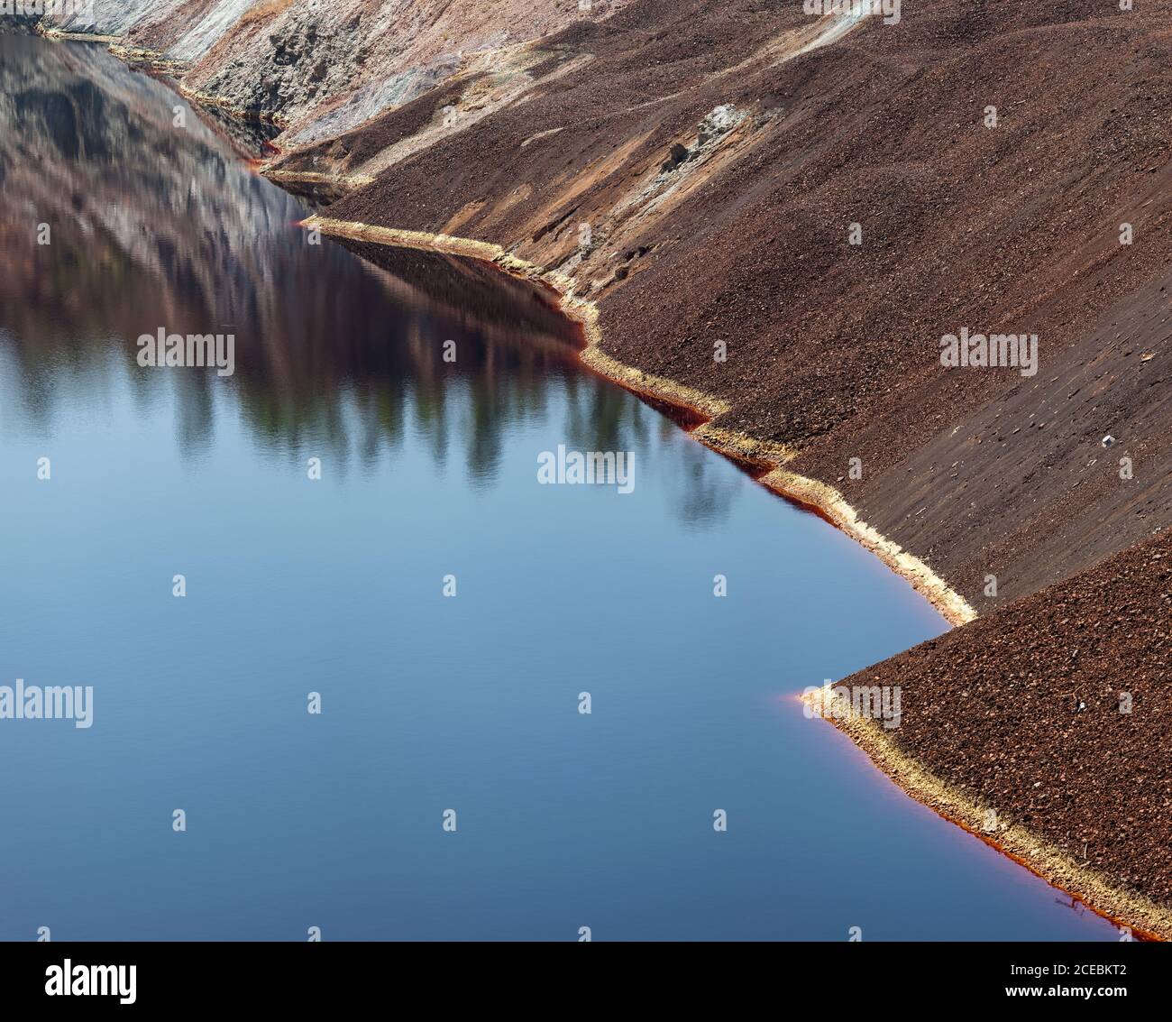 Calma superficie d'acqua vicino al pendio della cava nella miniera di Santo Domingos, Portogallo Foto Stock