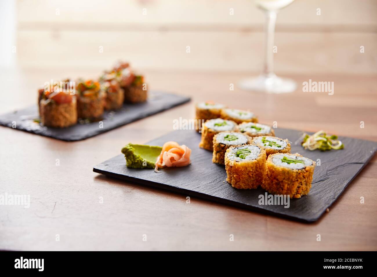 deliziosi pezzi di sushi californiano croccante e un bicchiere di vino Foto Stock