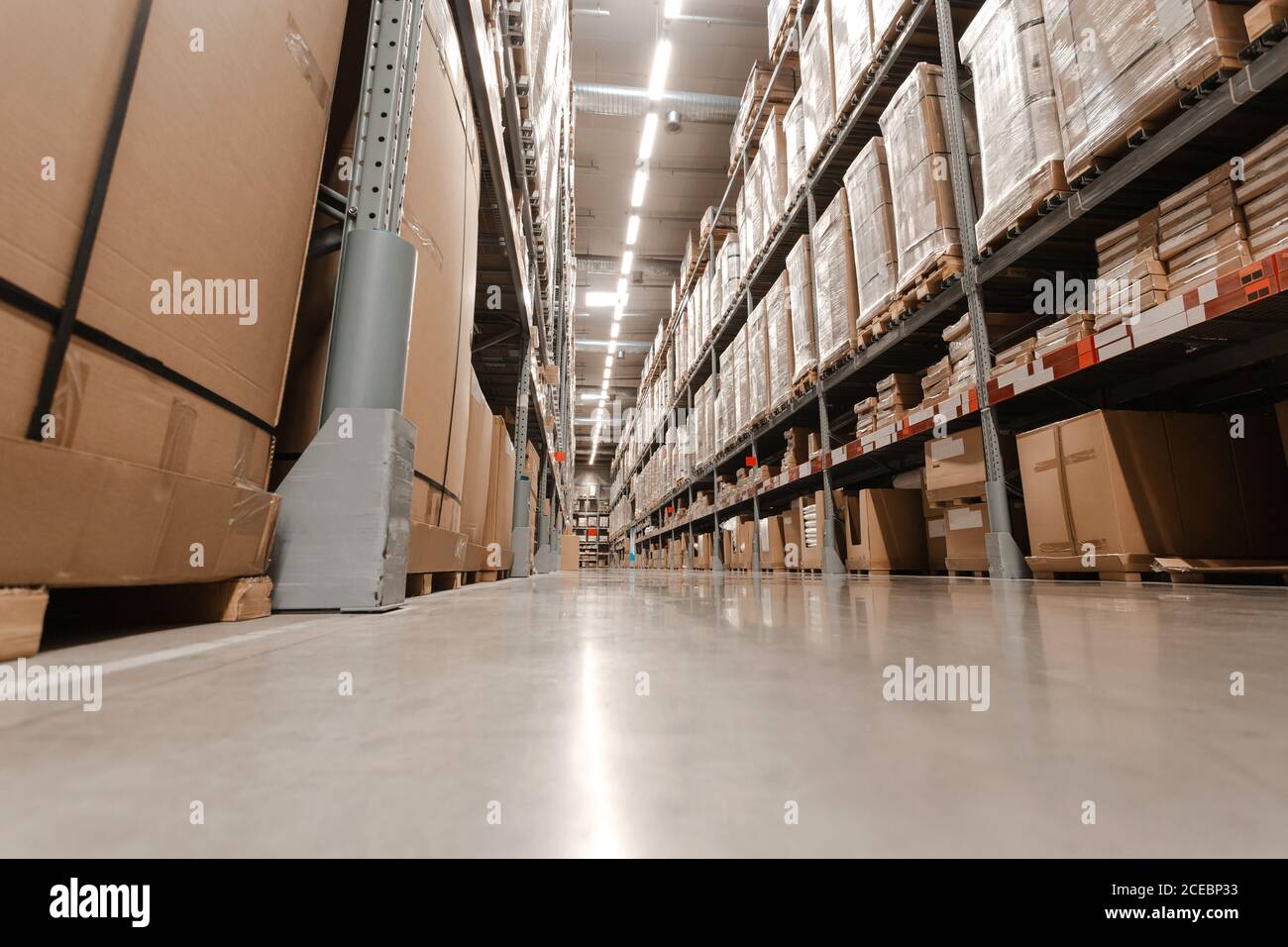 Interno magazzino con ripiani, pallet e scatole, file di ripiani con scatole merci in magazzino industriale moderno al magazzino di fabbrica. Foto Stock