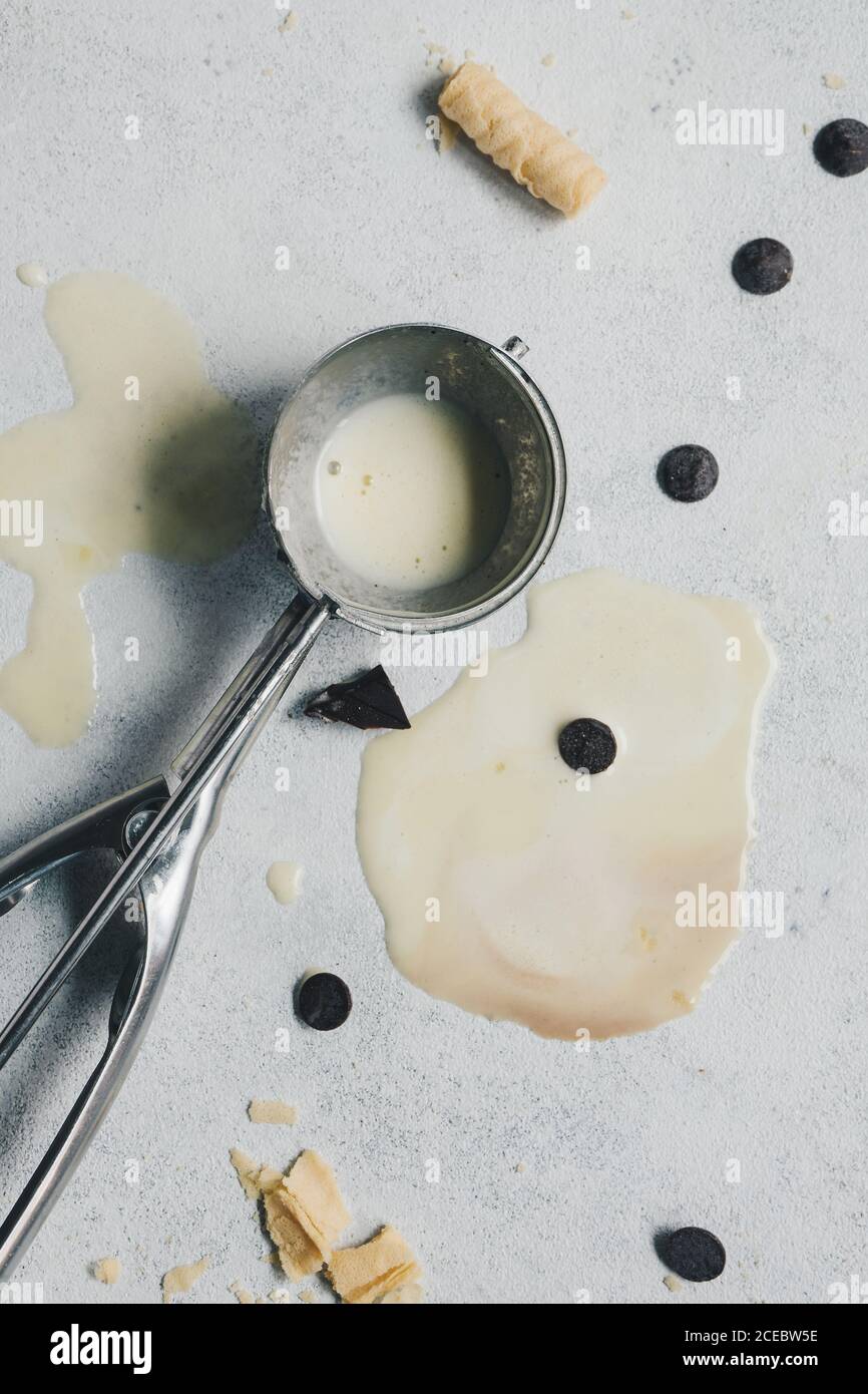 Il gelato alla vaniglia è stato fuso in un cucchiaio d'argento Foto Stock