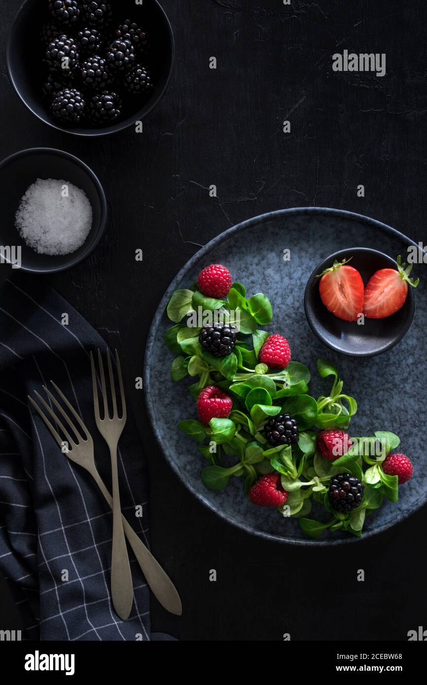 Insalata di frutti di bosco in un'atmosfera scura Foto Stock
