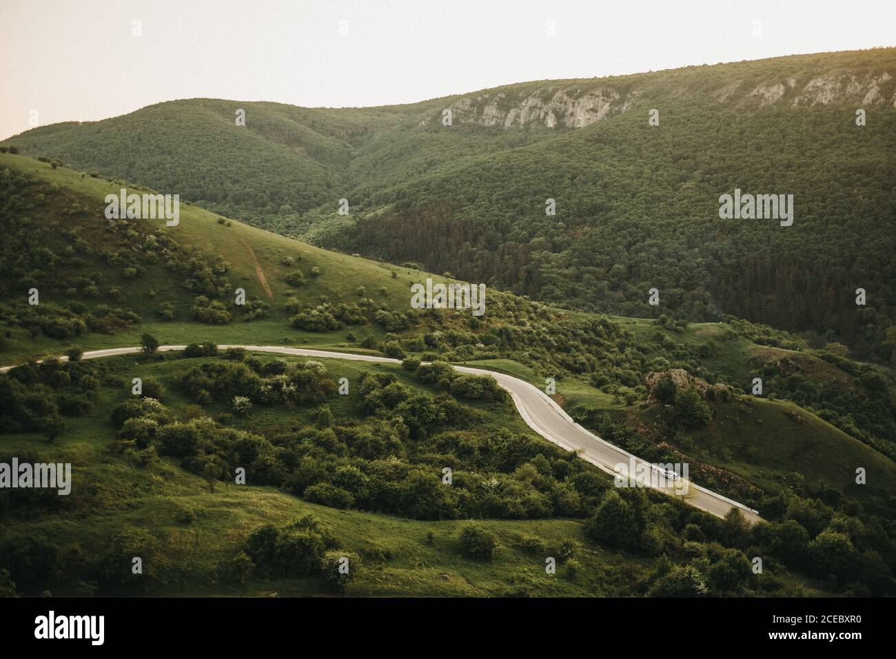 Vista mozzafiato del sole luminoso che splende sulle splendide montagne e. valle pittoresca Foto Stock
