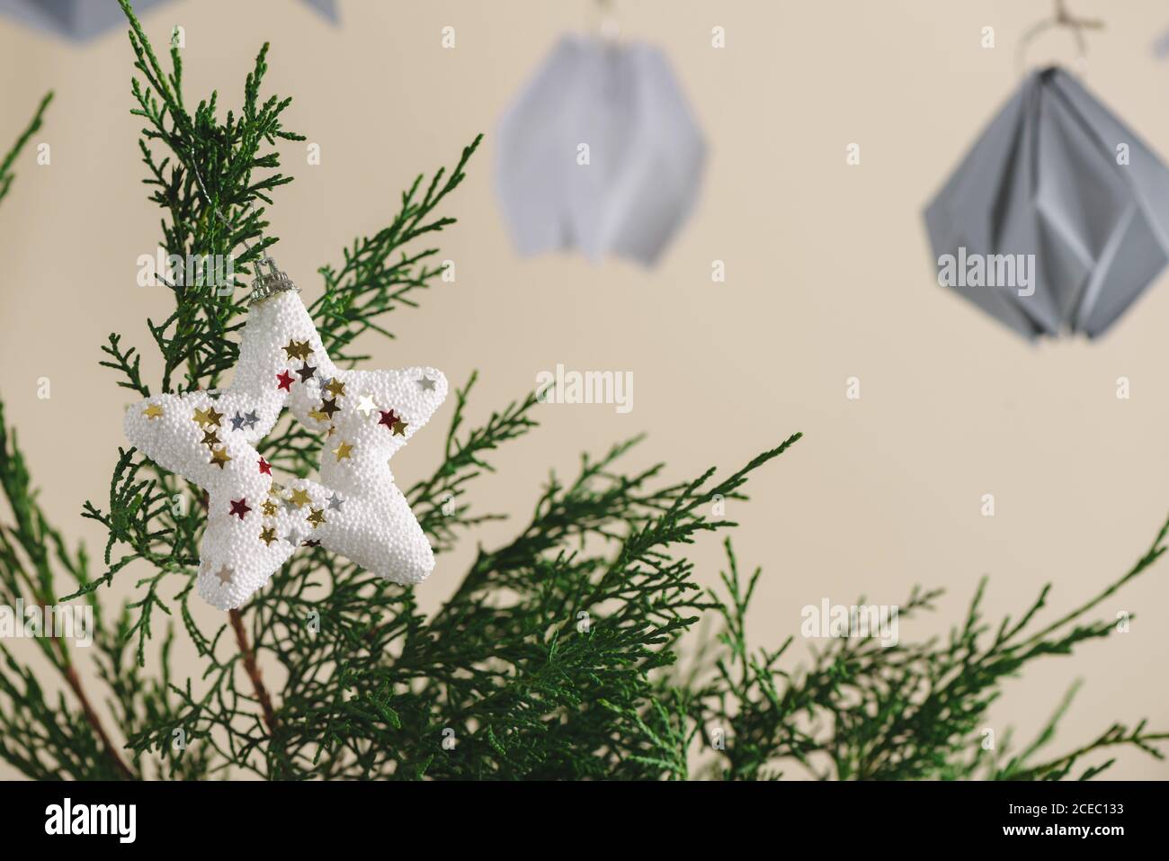 pino albero di natale in vaso, con stelle bianche hangingon il tavolo bianco Foto Stock