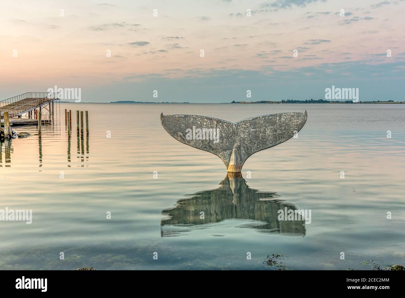 La coda delle balene, una scultura a Faaborg. Il bagno del porto si riflette nel mare e Avernako sullo sfondo, Faaborg, Danimarca, 16 agosto 2020 Foto Stock