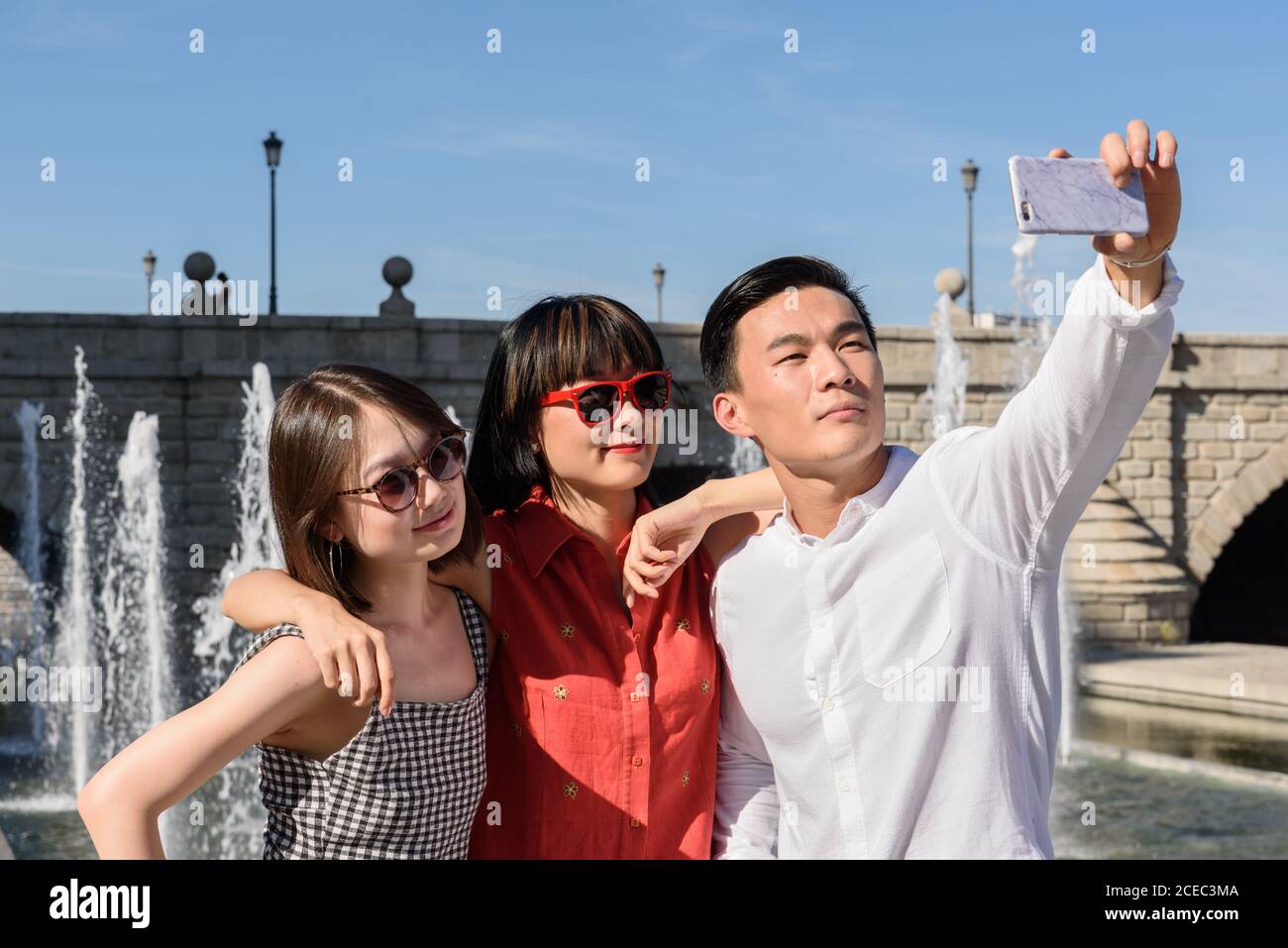 Turisti asiatici prendendo selfie vicino fontana Foto Stock