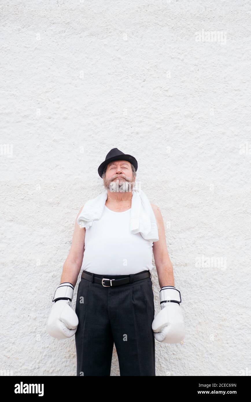 Uomo adulto in cappello e guanti bianchi di boxe a parete ruvida Foto stock  - Alamy