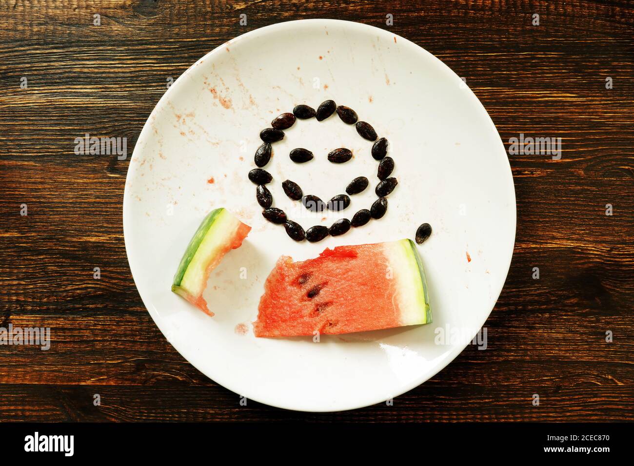 Dieta vegetariana di frutta. Una fetta di anguria e un sorriso su un piatto. Foto Stock