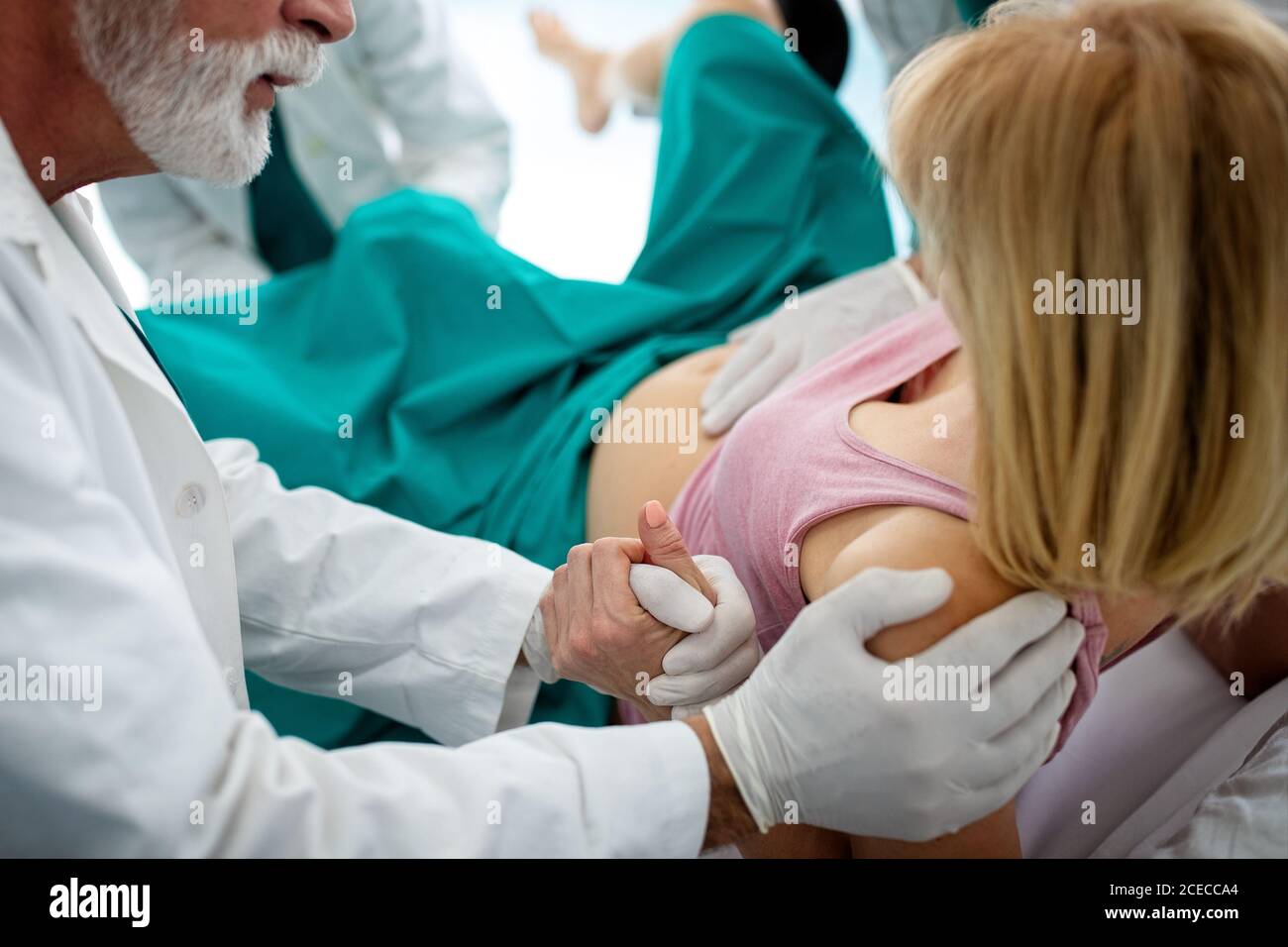 Donna che partorisce in ospedale con l'equipe medica Foto Stock