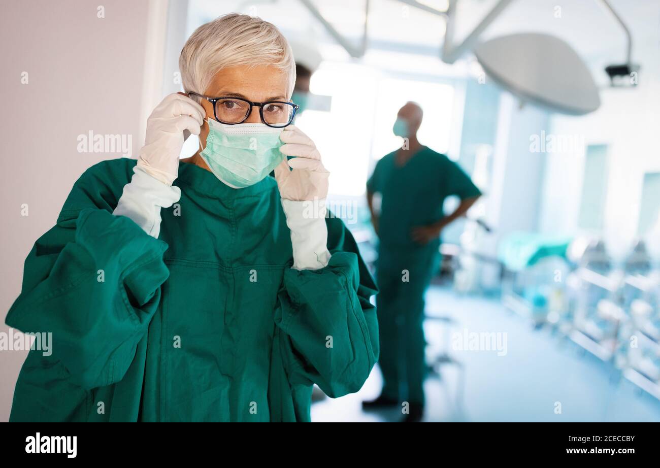 Ritratto di chirurgo femminile che indossa una maschera chirurgica durante l'intervento camera Foto Stock
