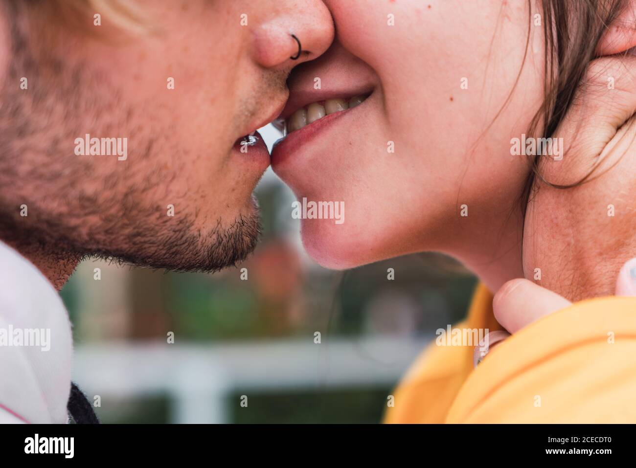 Primo piano di un giovane e una donna irriconoscibili che si baciano mentre si sono in piedi per strada Foto Stock