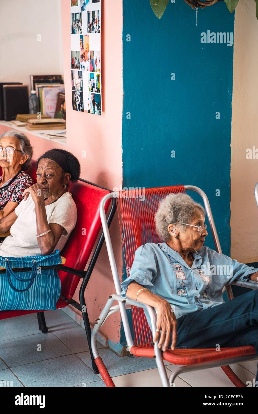 LA HABANA, CUBA - NOVEMBRE, 6, 2018: Vista laterale anziani afro-americani seduti in camera con ventilatore a Cuba Foto Stock