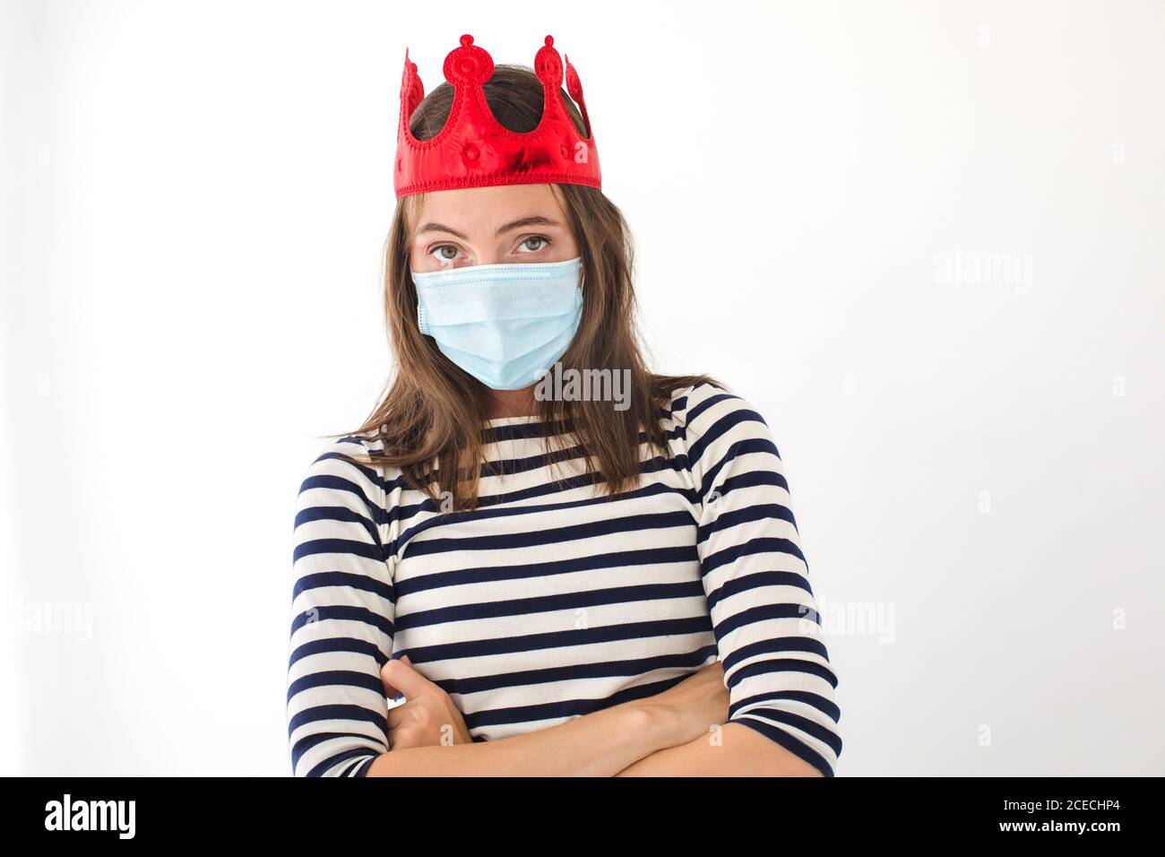 Donna con corona e maschera protettiva Foto Stock