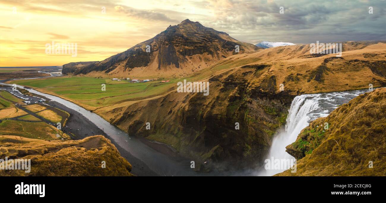 Vista aerea del paesaggio meraviglioso con le montagne texture e cascata sotto il cielo nuvoloso, Islanda. Foto Stock