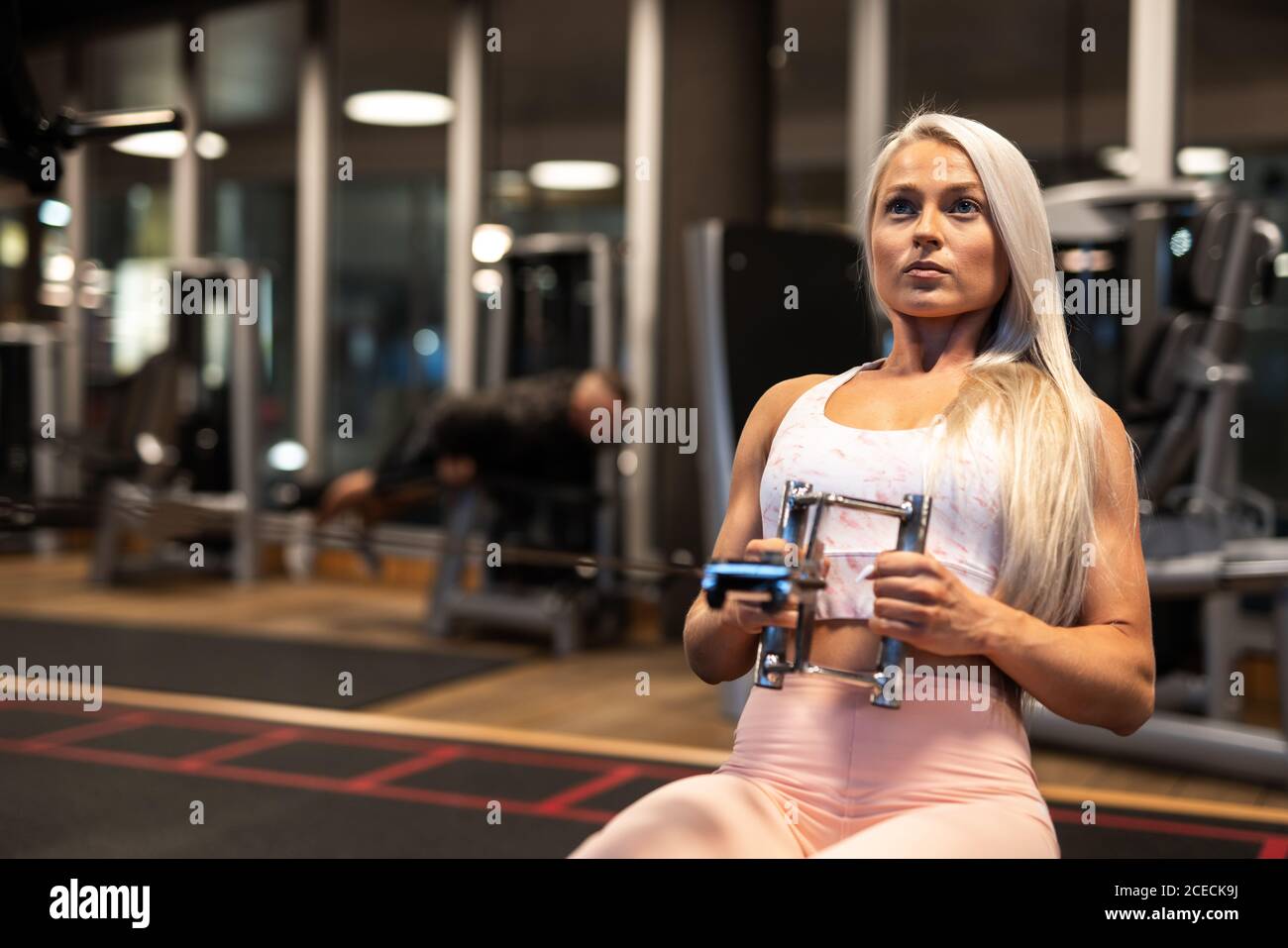 Donna atletica che fa l'esercitazione sull'apparecchiatura di addestramento Foto Stock Donna atletica che fa l'esercitazione sull'apparecchiatura di addestramento Foto Stock