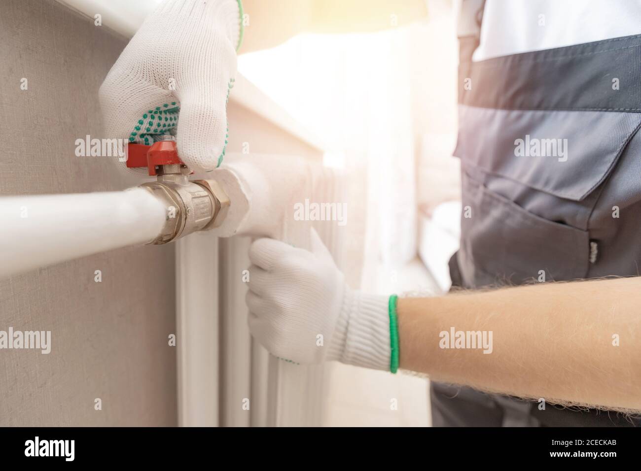 Idraulico uomo sta bloccando riparazioni radiatori di riscaldamento batteria in appartamento rubinetto Foto Stock