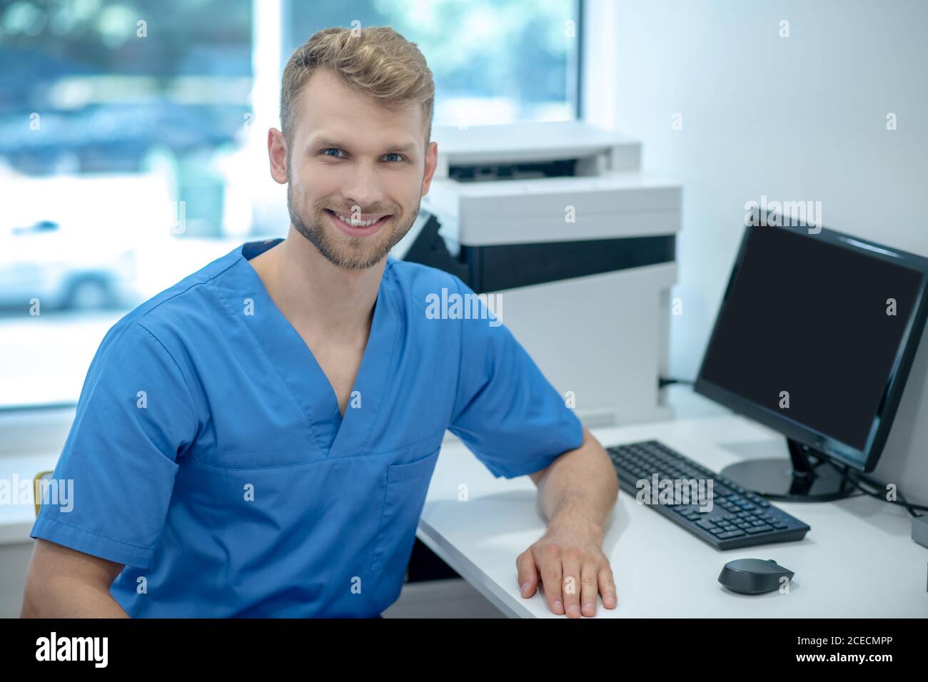 Giovane ragazza sorridente medica maschile in ufficio Foto Stock