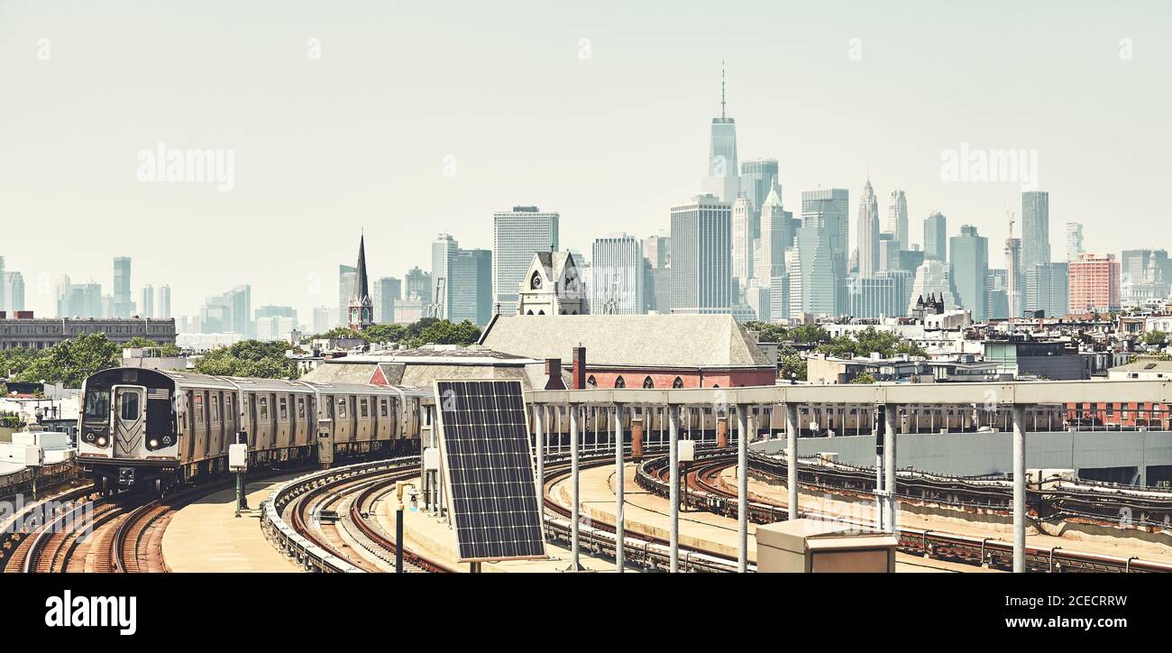 Treno della metropolitana di New York con skyline di Manhattan sullo sfondo, immagine colorata, USA. Foto Stock