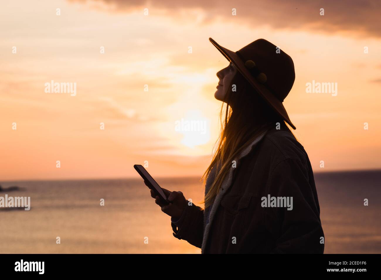 Donna in cappello al cielo di sera Foto stock - Alamy