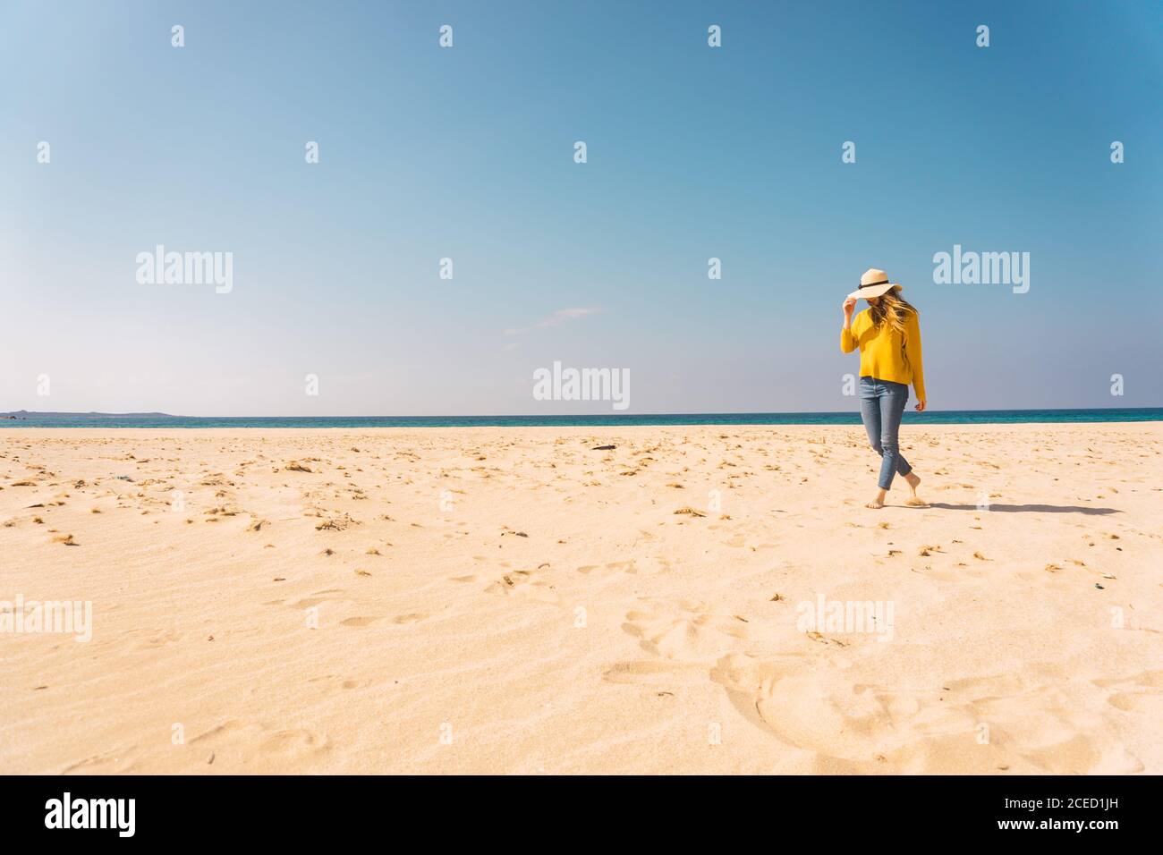 Donna in piedi sulla spiaggia sabbiosa Foto Stock