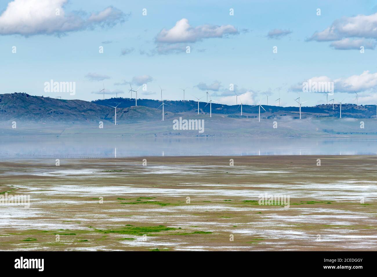 Le basse nuvole e le turbine eoliche si riflettono nel lago George, recentemente ricaricato, vicino a Canberra, ACT, Australia. Il lago è stato asciutto per molti anni. Foto Stock