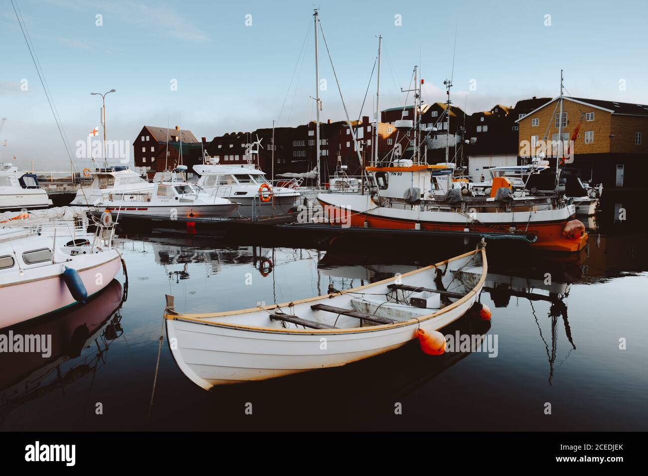 Piccole barche e diverse navi al molo dell'isola di Feroe Foto Stock