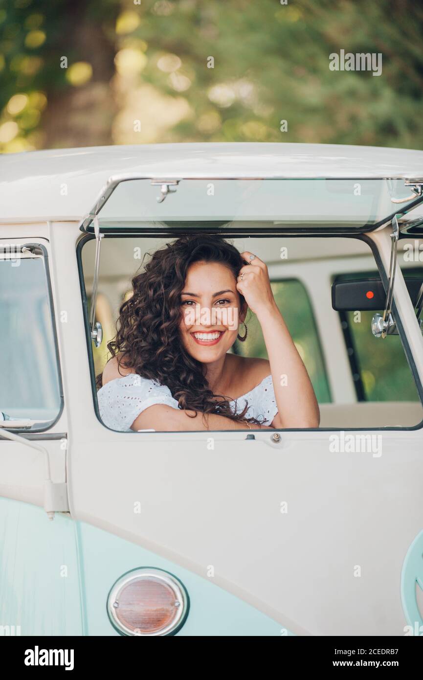 Donna sorridente seduta in auto retrò Foto Stock