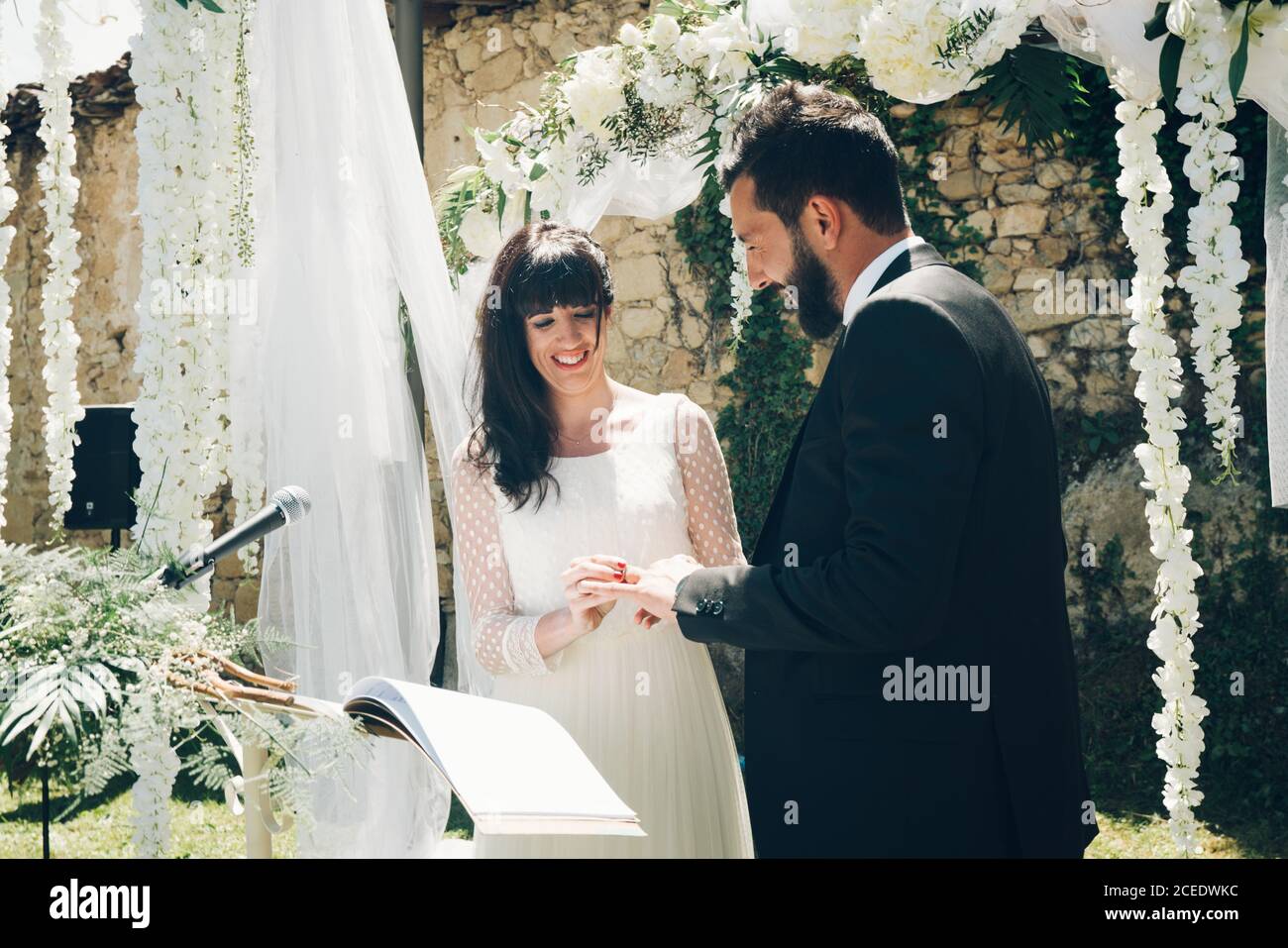 Sposo e sposo giovani che scambiano gli anelli di nozze Foto Stock